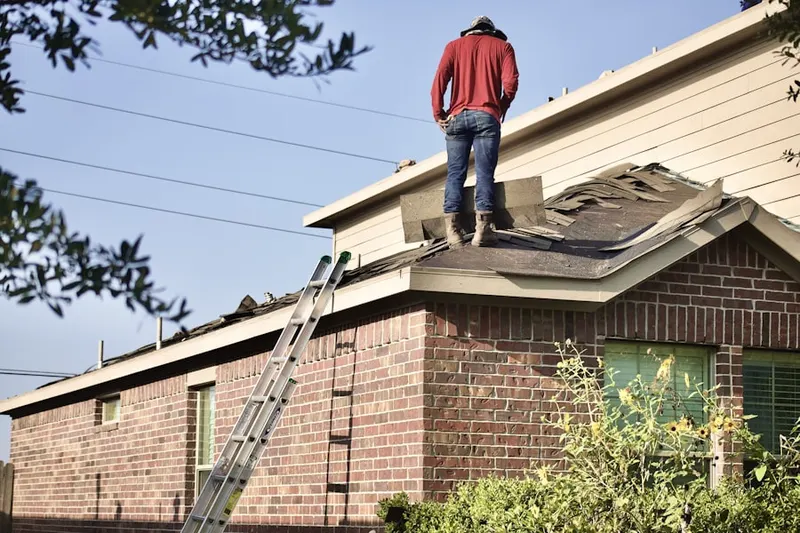 Professional roofer working on a residential roof in Sherman